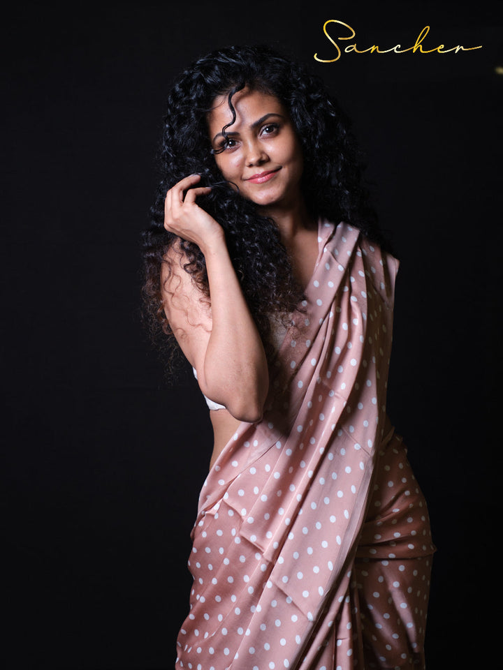 Dusty rose polka dot modal silk saree with white crop top styled against black background