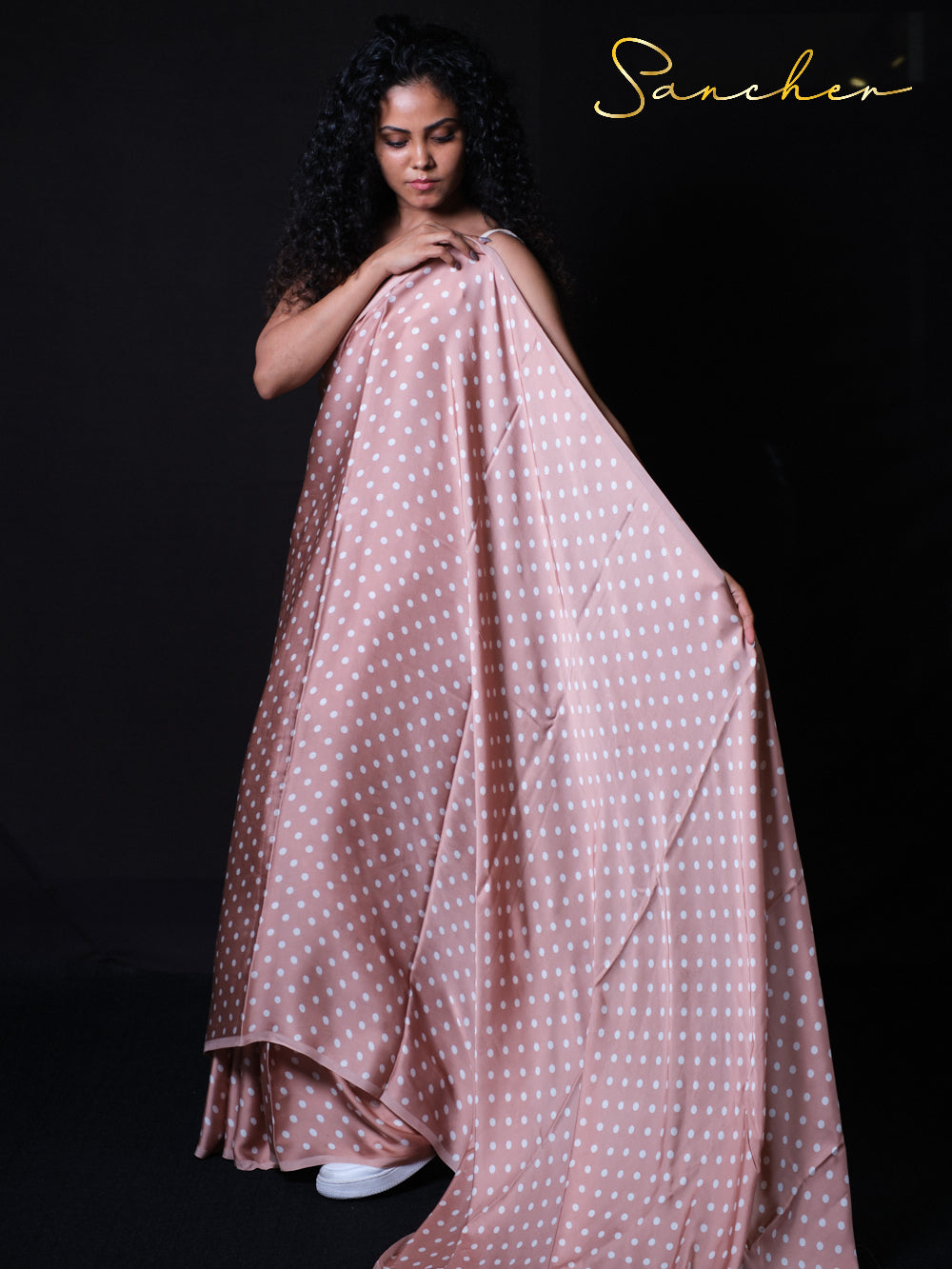Model showcasing the elegant drape of dusty rose polka dot saree with white blouse
