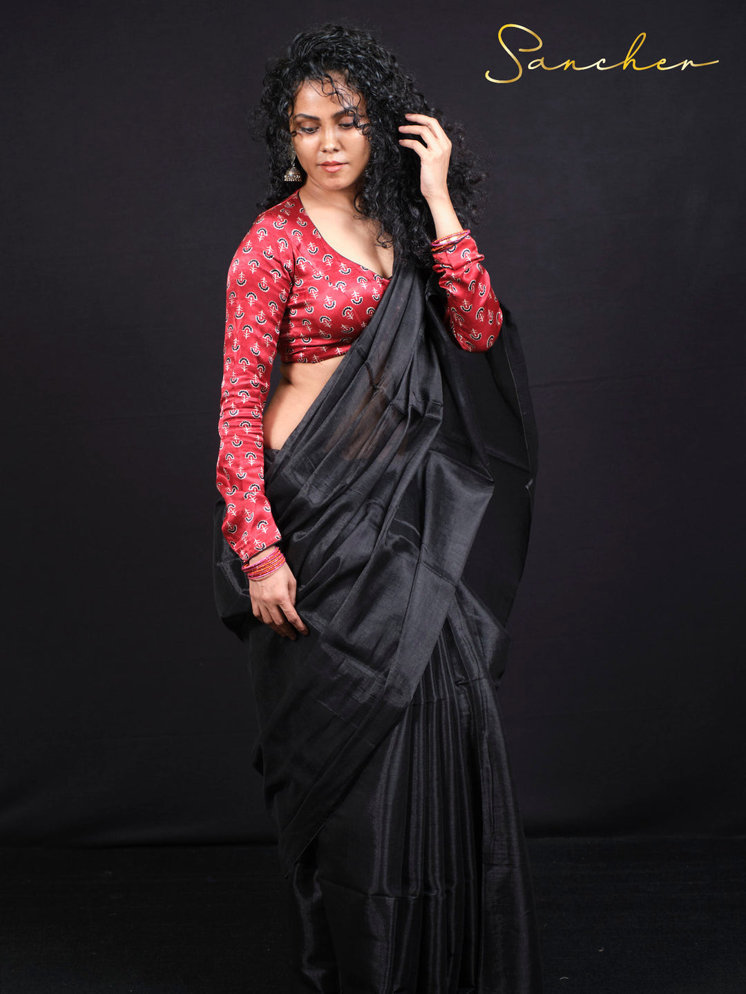 Woman wearing elegant black mul zari saree with red anchor print blouse, traditional Indian ethnic wear