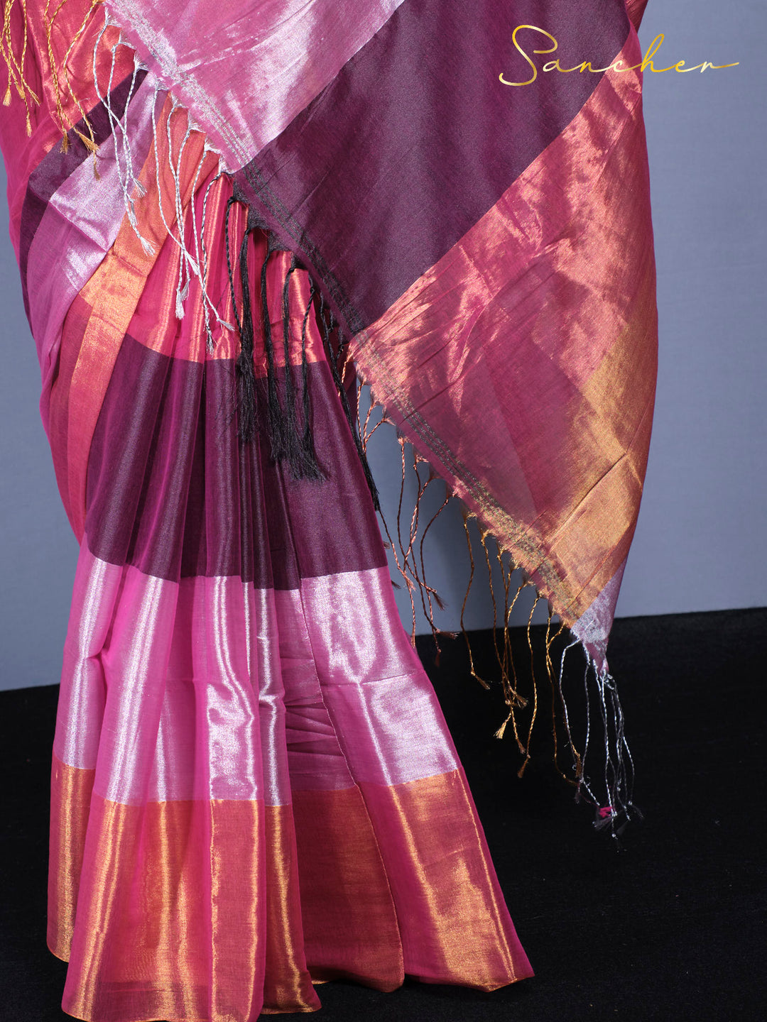 Detailed view of Mul Zari saree border showing golden threads and traditional tassels on pink purple fabric