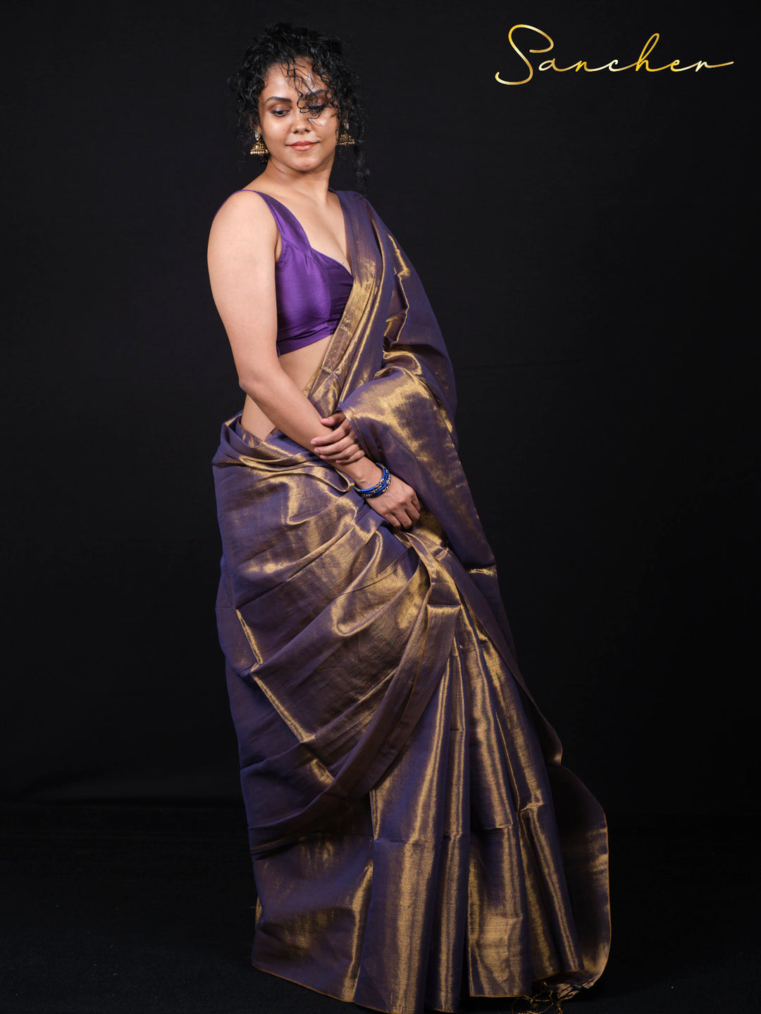 Woman wearing purple Mul Zari saree with golden border in elegant pose