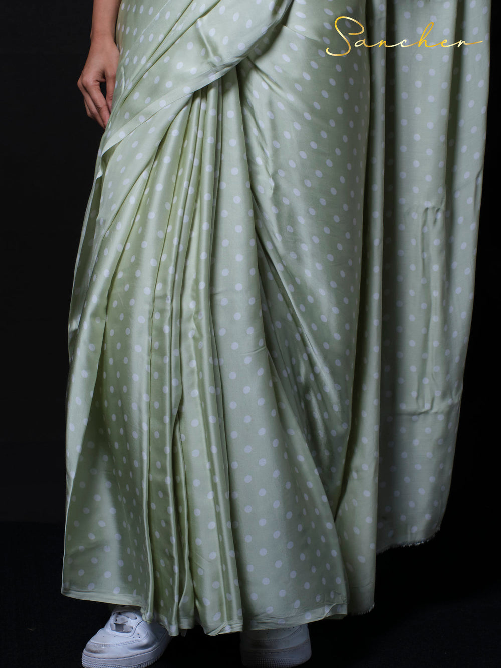 Detail shot of sage green modal silk fabric with white polka dot pattern