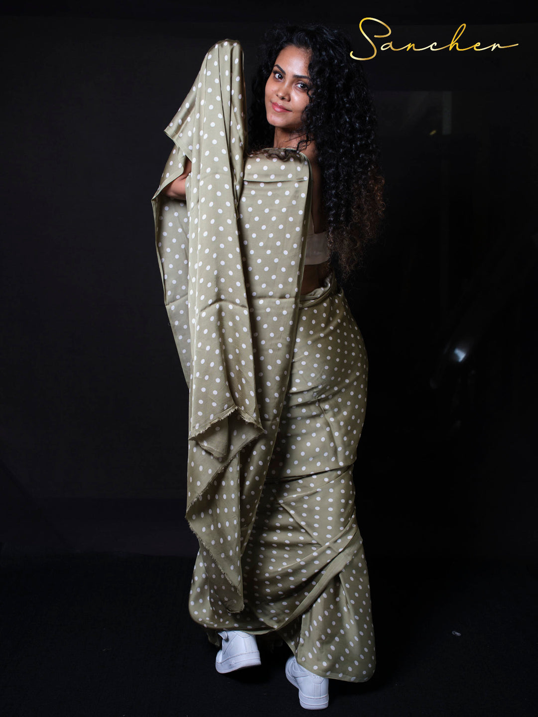 Woman holding polka dot modal silk saree fabric showing soft texture and premium quality material