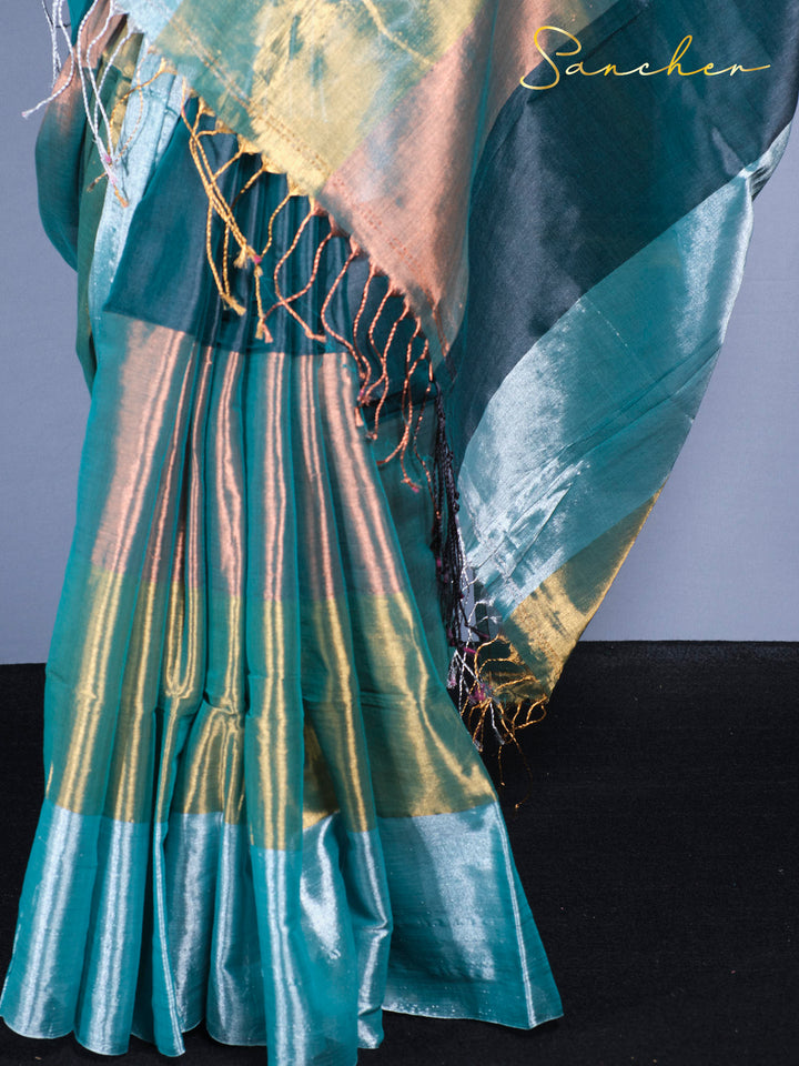 Close-up of mul zari saree fabric showing color-changing shimmer effect in teal and gold