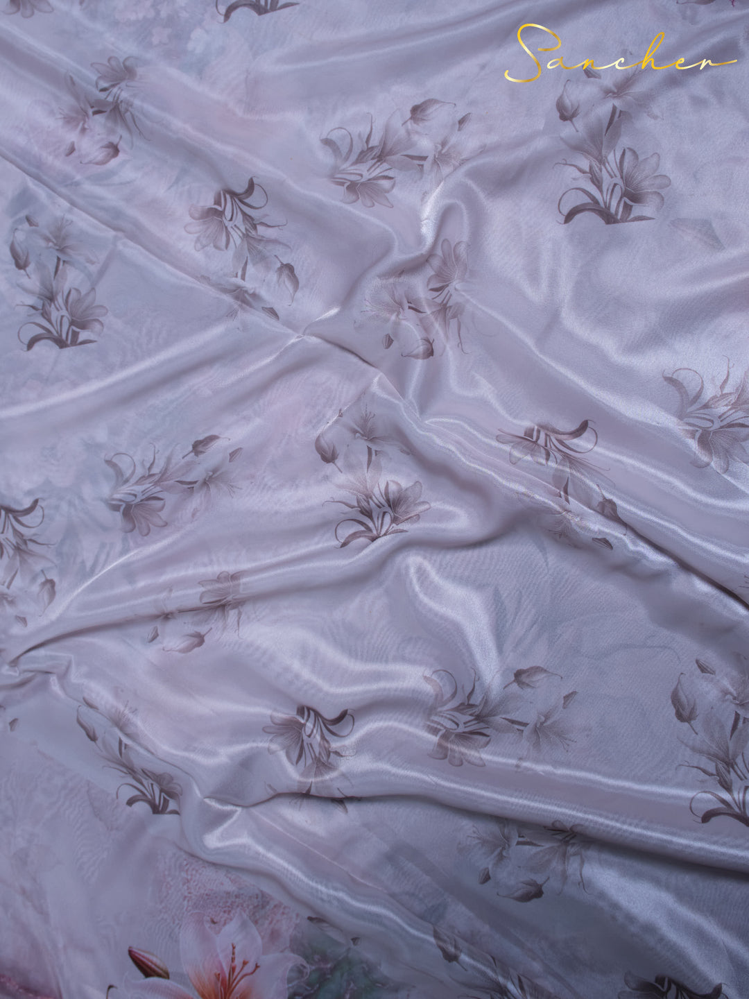 Close-up of premium satin silk fabric showing tulip and lily floral pattern details