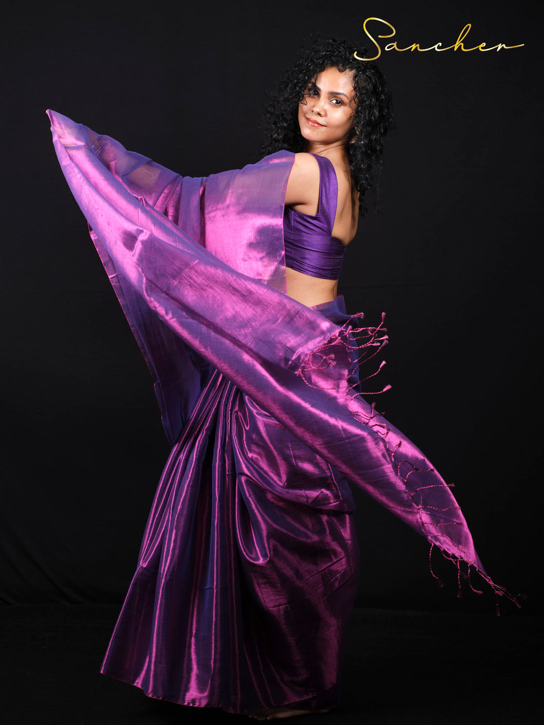 Dynamic pose showcasing purple silk saree flow and movement in studio photography