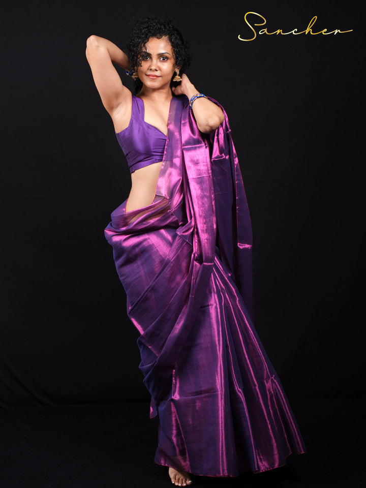 Woman wearing purple magenta mul zari saree in elegant pose against black background