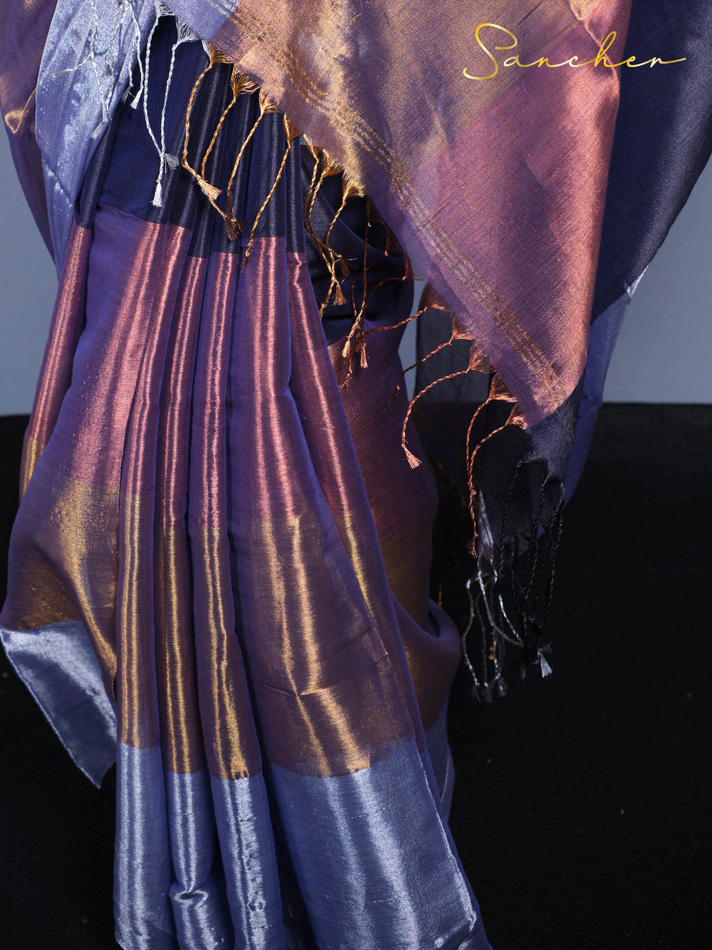 Close up detail of Mul Zari saree fabric showing golden threads and tassel work