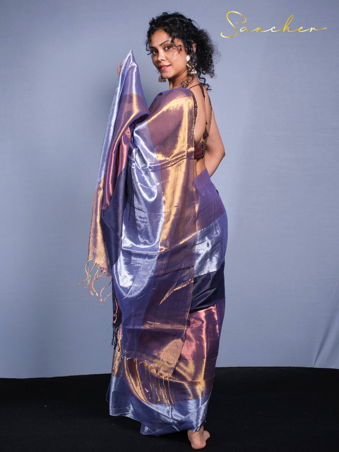 Dynamic Pose of wearing Soft Mul Zari cotton saree in midnight purple with golden highlights