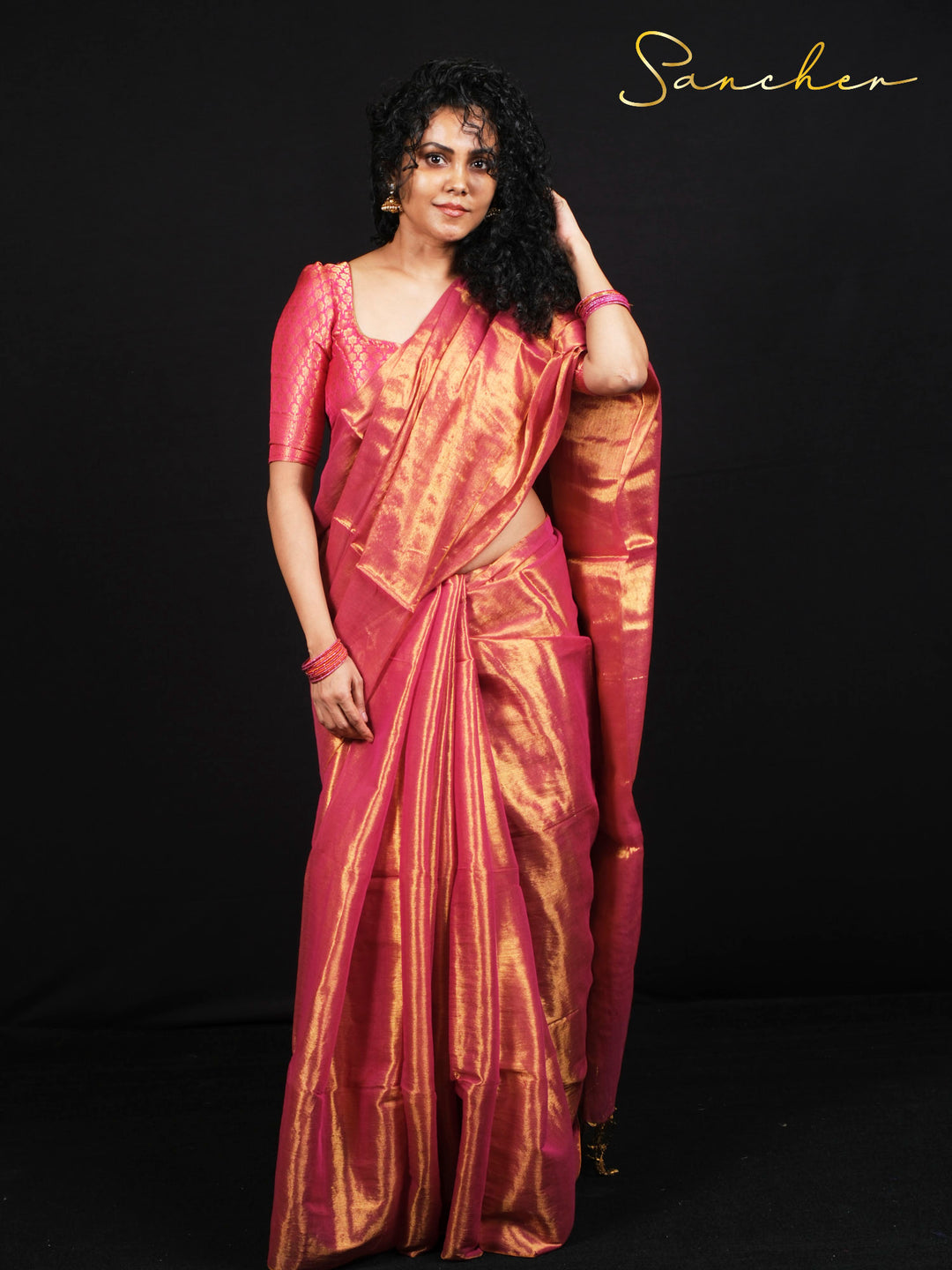 Woman wearing beautiful pink mul zari saree with golden work for festival celebration