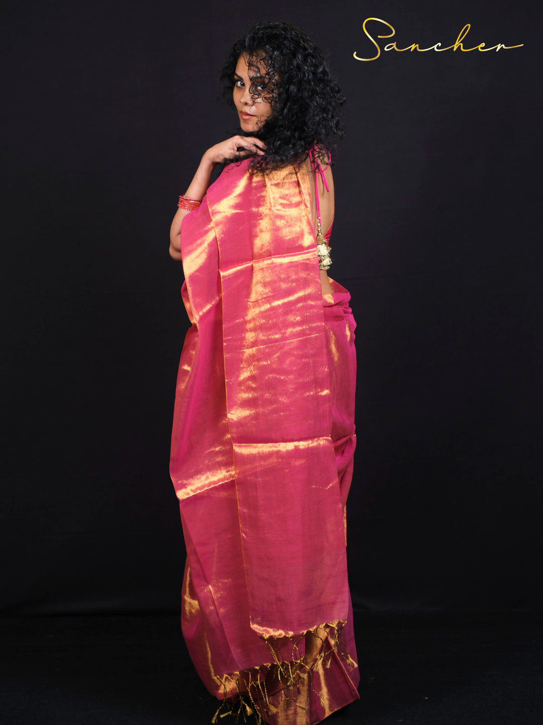 Side view of pink mul cotton saree with golden zari border and ethnic design.