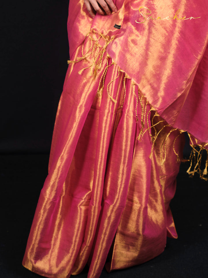 Close up detail of pink saree showing beautiful golden zari work and tassels