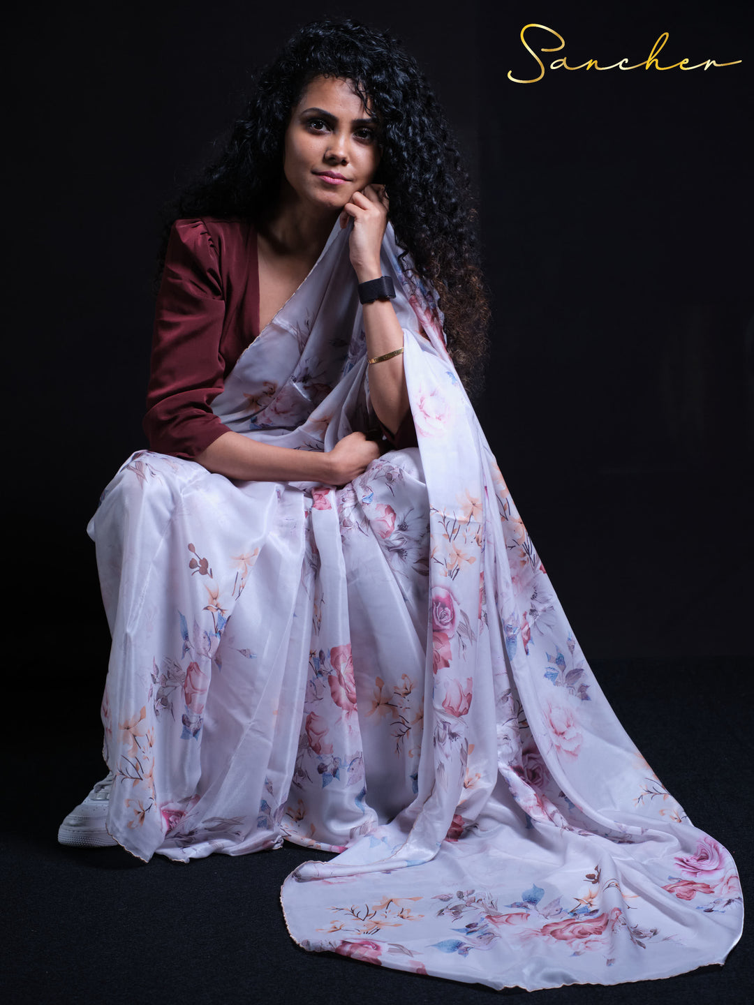 Premium white satin silk saree with pink and blue floral pattern - seated pose