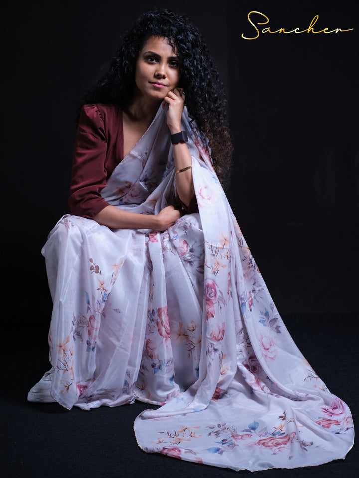 Premium white satin silk saree with pink and blue floral pattern - seated pose