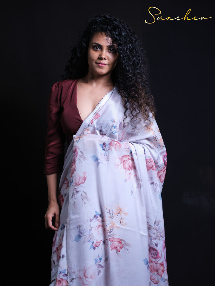 White silk saree with pink floral motifs paired with contrasting burgundy blouse