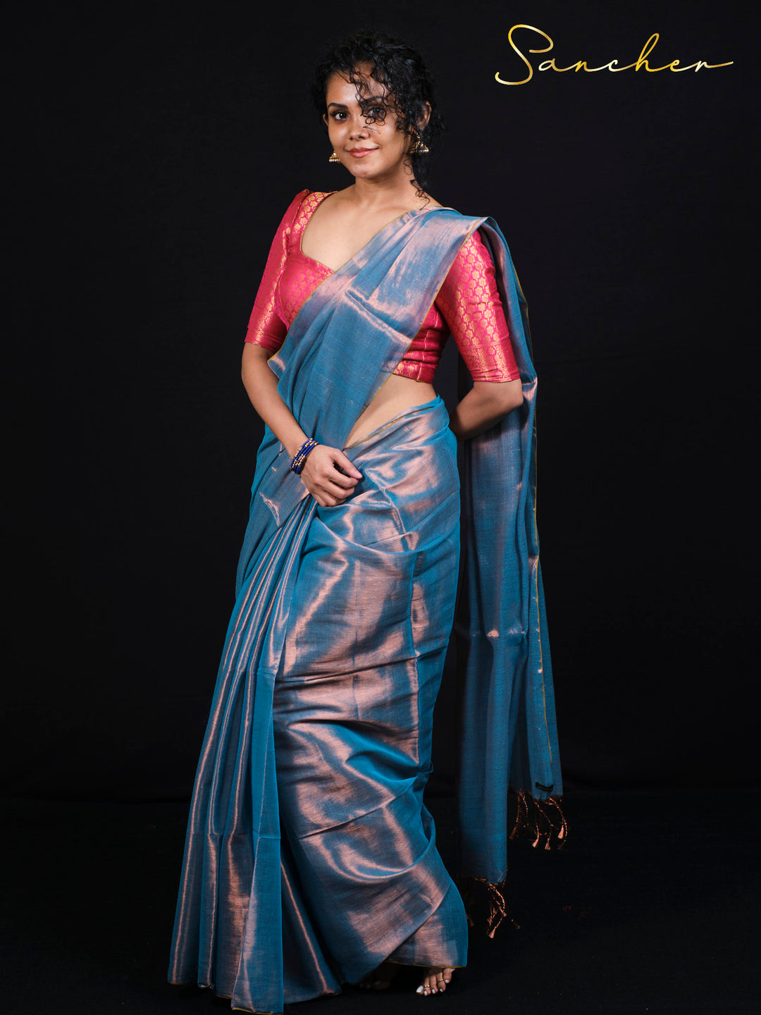 Woman wearing Sancher Serence Sea Blue Mul Zari saree with pink brocade blouse and traditional gold jewelry