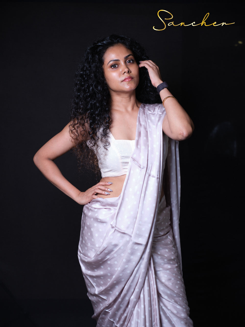 Close up of premium modal silk saree fabric showing delicate white polka dot pattern on Gray background