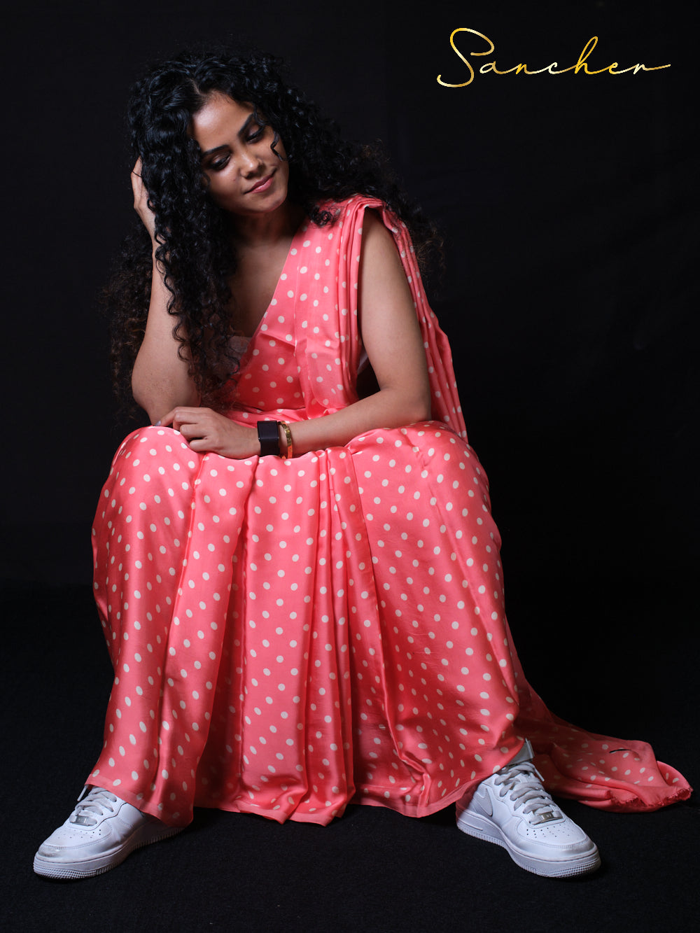 Casual sitting pose in polka dot modal silk saree with modern styling perfect for office wear and party occasions