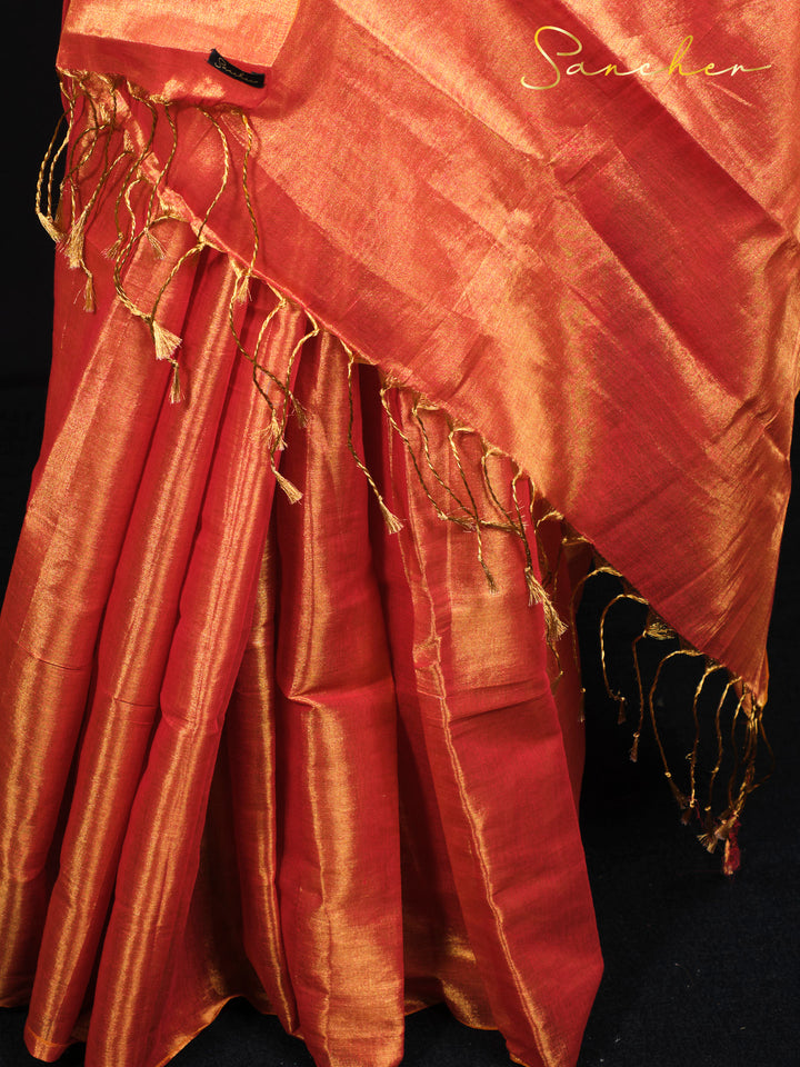 Detailed view of golden tassels and zari border work on premium sunset orange silk saree