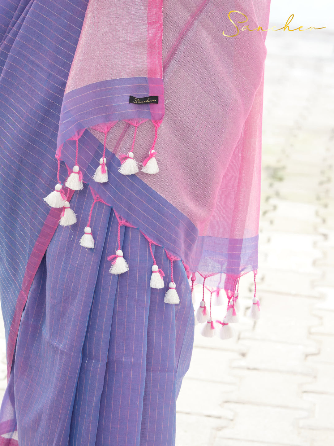 Close-up of lavender and pink mul cotton saree from best saree shop in Anna Nagar, showing intricate tassels and brand label, ideal for professional and casual office wear available at saree boutique and online.