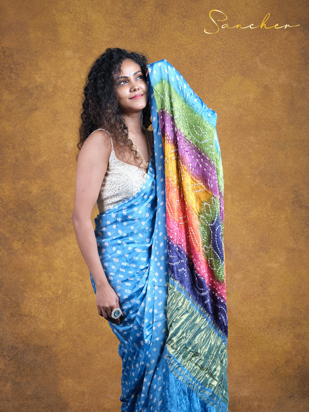 Chic Modal silk Bandhani saree for office wear from Sancher. Light blue with white spots and rainbow pallu, combining comfort and style. Anna Nagar's best saree shop for professional and casual workwear options.