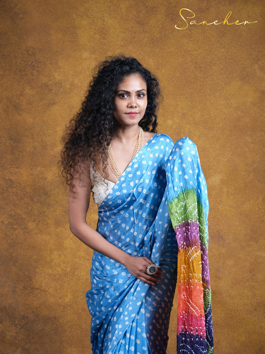  Stylish Modal silk Bandani saree showcasing versatile workwear from Sancher, a top saree boutique in Anna Nagar. Blue polka dot design with colorful pallu, perfect for professional office wear and casual corporate settings.