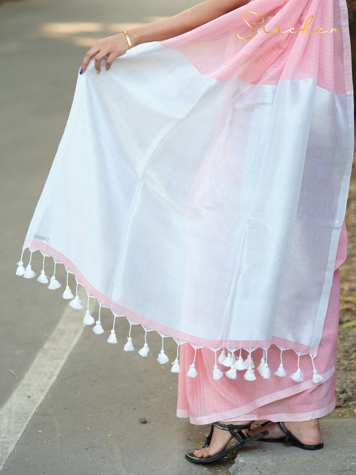 Closeup of a pink and white mul cotton saree with white tassels, showcasing delicate fabric and elegant design. Keywords: Mul Cotton Sarees, Workwear sarees, Casual Sarees for Office Wear, Pink sarees Online.