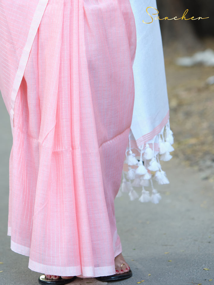 Detailed view of a pink mul cotton saree with white border and tassels, highlighting its texture and drape. Keywords: Mul Cotton Sarees, Workwear sarees, Pink sarees Online, Saree Boutique in Anna Nagar.