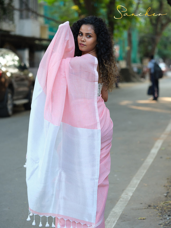 Woman in a pink and white mul cotton saree looking over her shoulder, displaying the saree's elegant drape and suitability for professional settings. Keywords: Workwear sarees, Professional Office wear Sarees, Saree Boutique in Anna Nagar, Pink sarees Online.