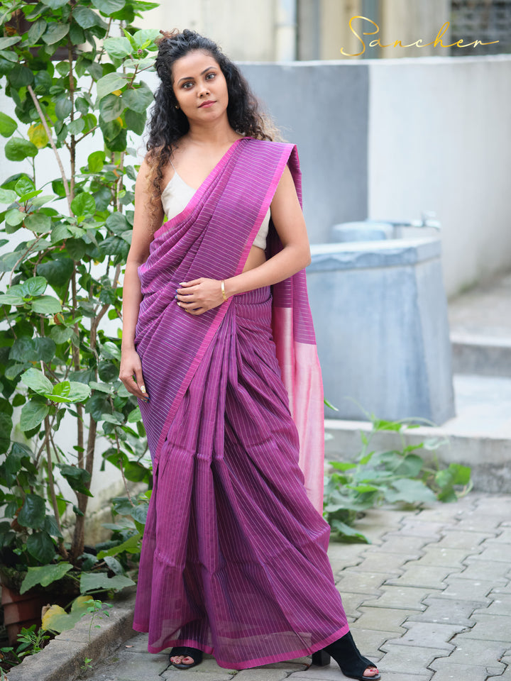 Woman wearing a purple striped mul cotton saree with a pink border, standing amidst greenery, perfect for casual office wear. Keywords: Mul Cotton Sarees, Best Sarees Shops in Anna Nagar, Casual Sarees for Office Wear, Workwear sarees