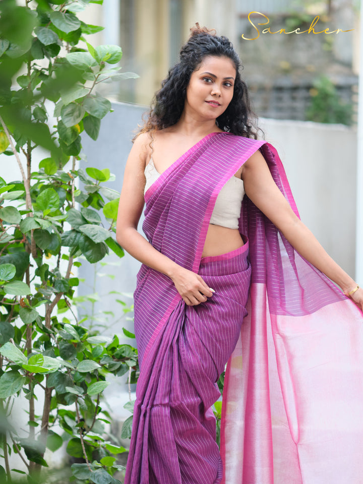 Woman in purple striped mul cotton saree and white crop top, posing outdoors. Casual saree for office wear from best saree shop in Anna Nagar.