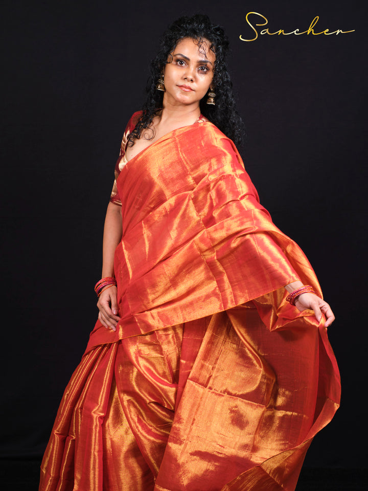 Close-up of sunset orange Mul Zari silk saree showcasing golden zari work and elegant draping 